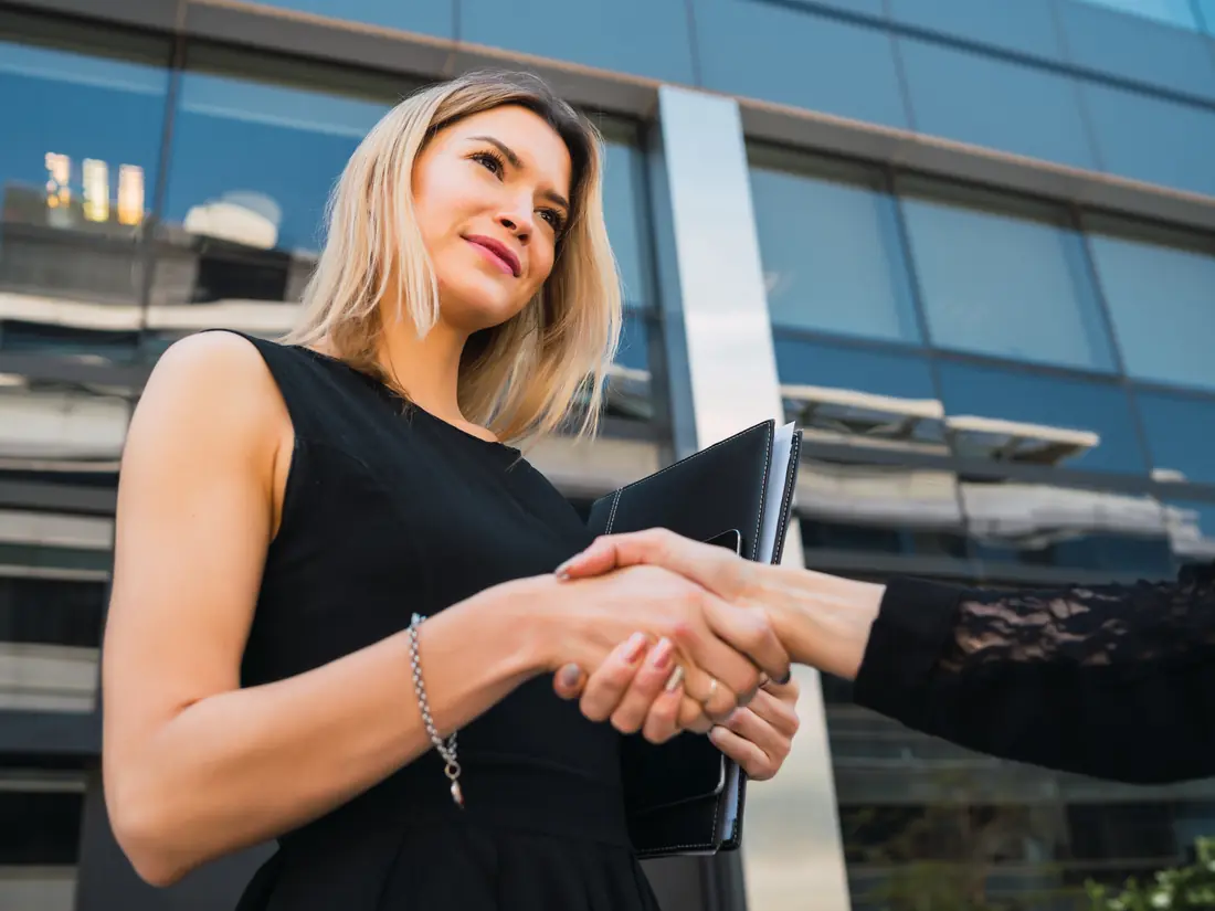 Partners shaking hands outside an office building
